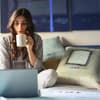 frau im bett mit kaffee und laptop