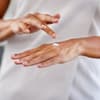 frau mit handcreme cremt hände ein