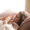 Frau liegt krank im Bett
