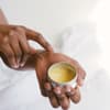 Frau hält Body Butter in den Händen