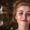 Lachende Frau mit Blüten im Haar