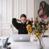 Frau sitzt an Schreibtisch mit Laptop