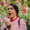 Frau die in der Natur niest