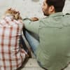 Frau und Mann sitzen mit dem Rücken zur Kamera