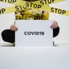 Mensch mit Corona Schild