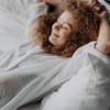 Frau liegt in Bett