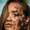 Frau scheint Sonne ins Gesicht
