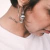 Frau mit einem Tattoo am Hals