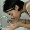 Mädchen wäscht sich im Waschbecken ihr Gesicht