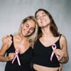 Zwei Frauen mit rosa Schleife zum Brustkrebs Monat