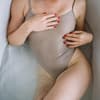 Frau in der Badewanne mit beigem Badeanzug