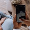 Frau hält Handy mit TikTok App hoch