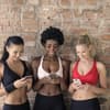 Frauen in Sport-Outfit mit Handy in der Hand