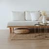 Beiges Sofa auf einem Jute-Teppich mit Deko