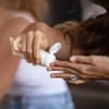 Frau cremt ihre Hände mit Handcreme ein