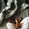Frau sitzt mit Frühstück im Bett
