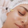 Spritze an Augenringe einer Frau mit geschlossenen Augen