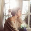 Frau schaut traurig aus dem Fenster