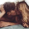 Mann und Frau kuessen sich unter Decke