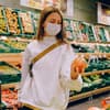 Frau im Supermarkt in der Obst- und Gemüseabteilung