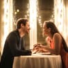 Valentinstag Date: Mann und Frau sitzen an einem Tisch der mit Lichterketten geschmückt ist