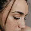 Wachsen Wimpern nach: Frau mit Sommersprossen und braunen Haaren
