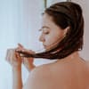 Frau unter der Dusche mit nassen Haaren