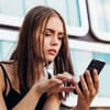 Frau schaut besorgt auf Handy