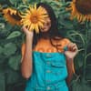 Horoskop: Frau mit Sonnenblume vor dem Gesicht