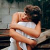 Horoskop: Traurige Frau umarmt sich selbst