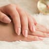 Hand mit natürlichen Gelnägeln in rosa