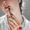 Lippenstift auftragen rote Fingernägel