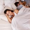 Frau liegt traurig im Bett