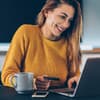Frau sitzt am Laptop beim Onlineshopping