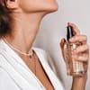 Frau sprüht Parfum auf