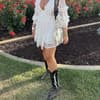 Bloggerin trägt weißes Spitzenkleid mit Cowboy-Boots