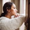 Unglückliche Frau schaut aus dem Fenster