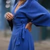 Frau trägt blaues Wickelkleid