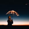 Frau mit Regenschirm vor Sternhimmel