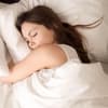 Frau liegt im Bett und träumt