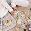 Frau hat vor sich Tarot-Karten und Kristalle liegen