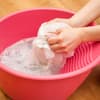 Wäsche wird in Schüssel gewaschen