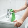 Frau putzt Waschbecken Badezimmer
