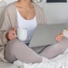 Frau sitzt in Thermowäsche Zuhause auf der Couch