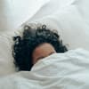 Frau mit Locken im Bett