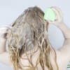 Frau benutzt festes Shampoo