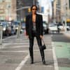 Frau trägt Leggings mit Stiefel und Blazer