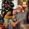 Tochter mit Vater vor Weihnachtsbaum