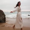 Frau steht am Strand