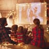 Familie schaut Weihnachtsfilme auf Beamer
